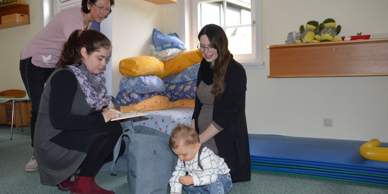 Die zwei Familienpatinnen Alexa Haubold (hinten, stehend) und Daniela Neff (vorne links) spielen mit dem kleinen Luca, dem Sohn von Josi Guth (rechts). Bild: Greck