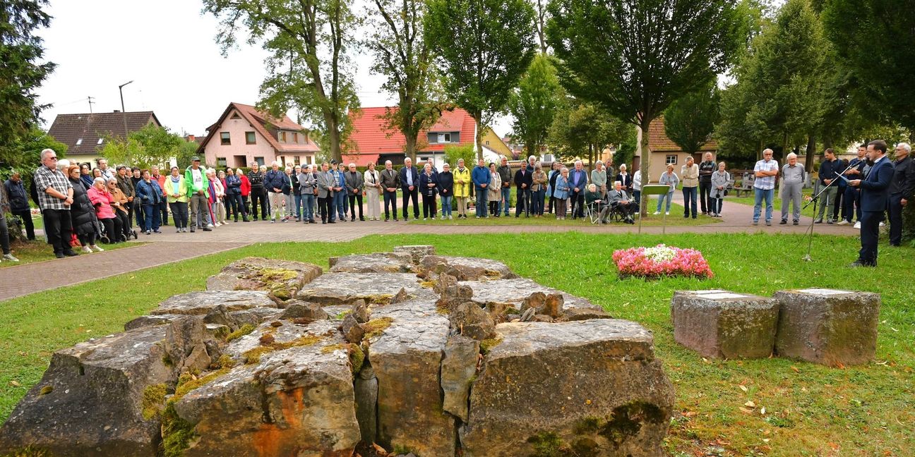 Gedenkfeier am 80. Jahrestag des Bombenangriffs am Mahnmal der gebrochenen Steine auf dem Magstadter Friedhof. Rechts am Mikrofon Magstadts Bürgermeister Florian Glock.Bild: Reichert