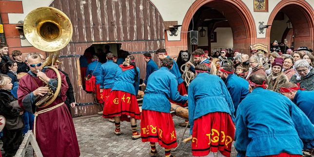 Mit der Ramme haben die starken Männer ein Loch in das Rathaustür gestoßen. Die Hexen halten sich schon bereit auf den Sturm ins Rathaus.