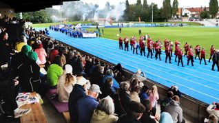 Timo Kächele und die Stadtkapelle führen die Sportler ins sanierte Stadion.