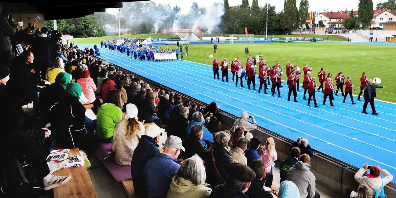 Timo Kächele und die Stadtkapelle führen die Sportler ins sanierte Stadion.