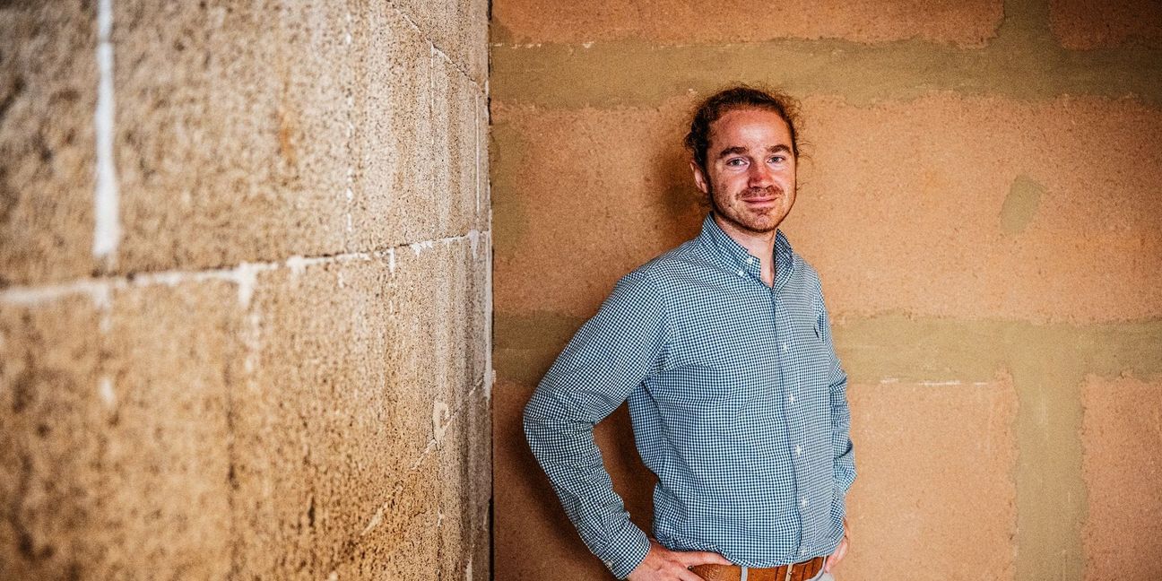 Henrik Pauly im  Hanfhaus in Tübingen.  Auf der linken Wand sind  die Bausteine aus Hanfkalk zu erkennen, die rechte Seite wurde bereits mit Trockenbauplatten aus Lehm verputzt.