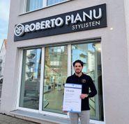 Alessandro Pianu hält stolz die Urkunde in seinen Händen.