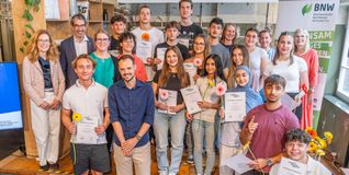 Die Schülerinnen und Schüler des Kaufmännischen Schulzentrums mit Staatssekretär Andre Baumann (Zweiter von links), Vorständin Anita Merzbacher (hinten rechts) sowie begleitenden Lehrkräften und Vertreterinnen der Partnerunternehmen.