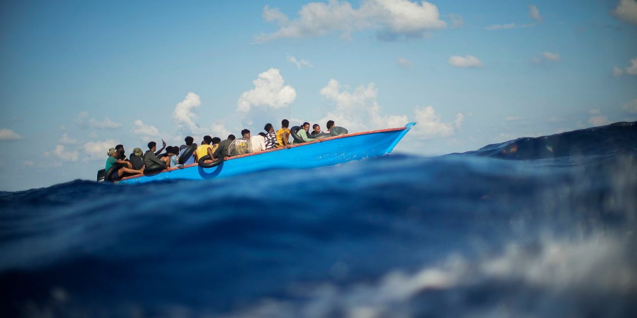 Migranten sitzen in einem Holzboot im Mittelmeer nahe der Insel Lampedusa: Die kleine Insel gehört seit Jahren zu den Brennpunkten illegaler Migration (Archivfoto).