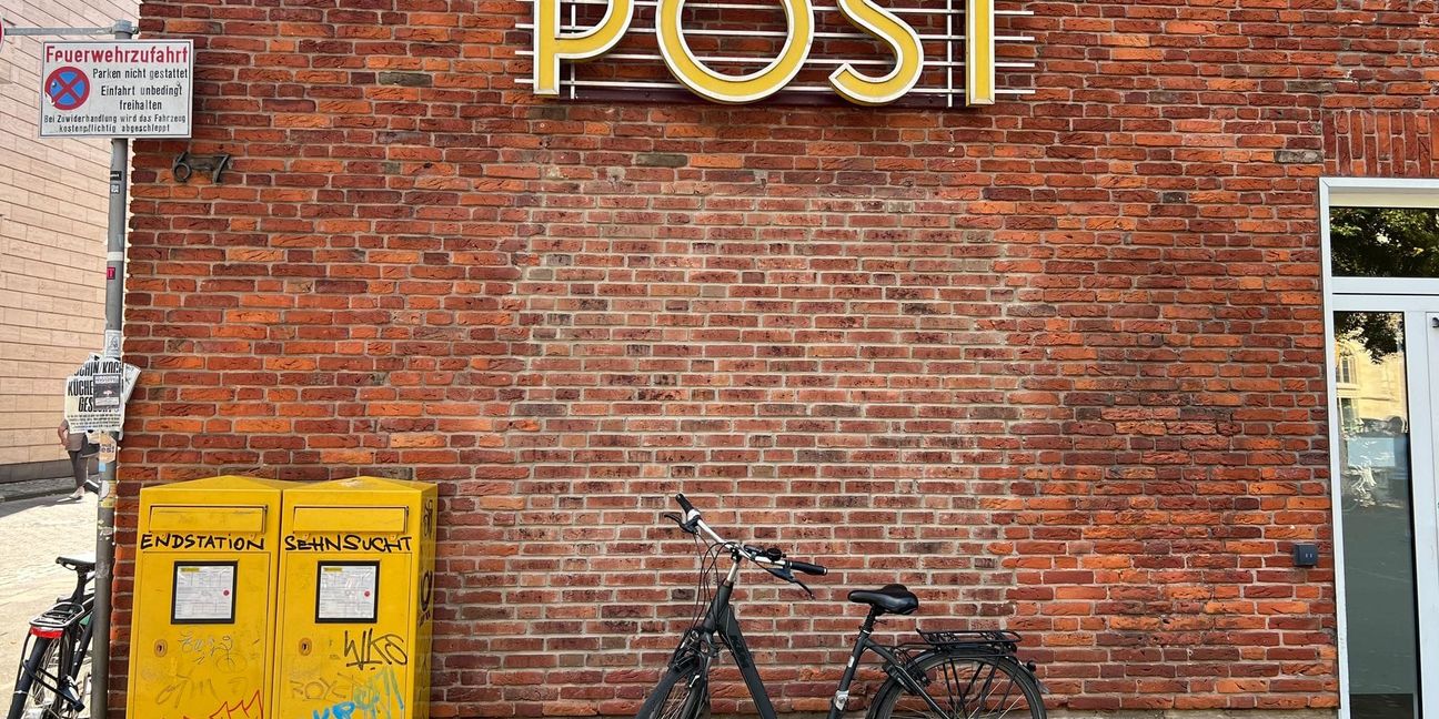 Ein Fahrrad steht vor einer Filiale der Postbank, die als Postfiliale fungiert. Anderswo in Deutschland gibt es keine Postfilialen, obwohl es sie einer staatlichen Vorschrift zufolge geben müsste.