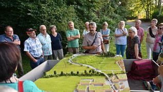 Magstadts früherer Bürgermeister Dr. Hans-Ulrich Merz (kariertes Hemd) erläutert am Modell der Osttangente die Planungen der Gemeinde zum Schutz vor Hochwasser.  Bild: Reichert