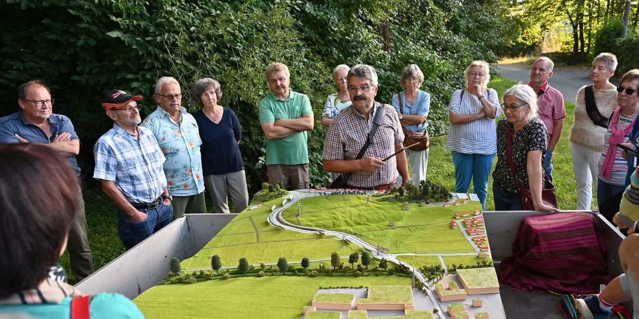 Magstadts früherer Bürgermeister Dr. Hans-Ulrich Merz (kariertes Hemd) erläutert am Modell der Osttangente die Planungen der Gemeinde zum Schutz vor Hochwasser.  Bild: Reichert