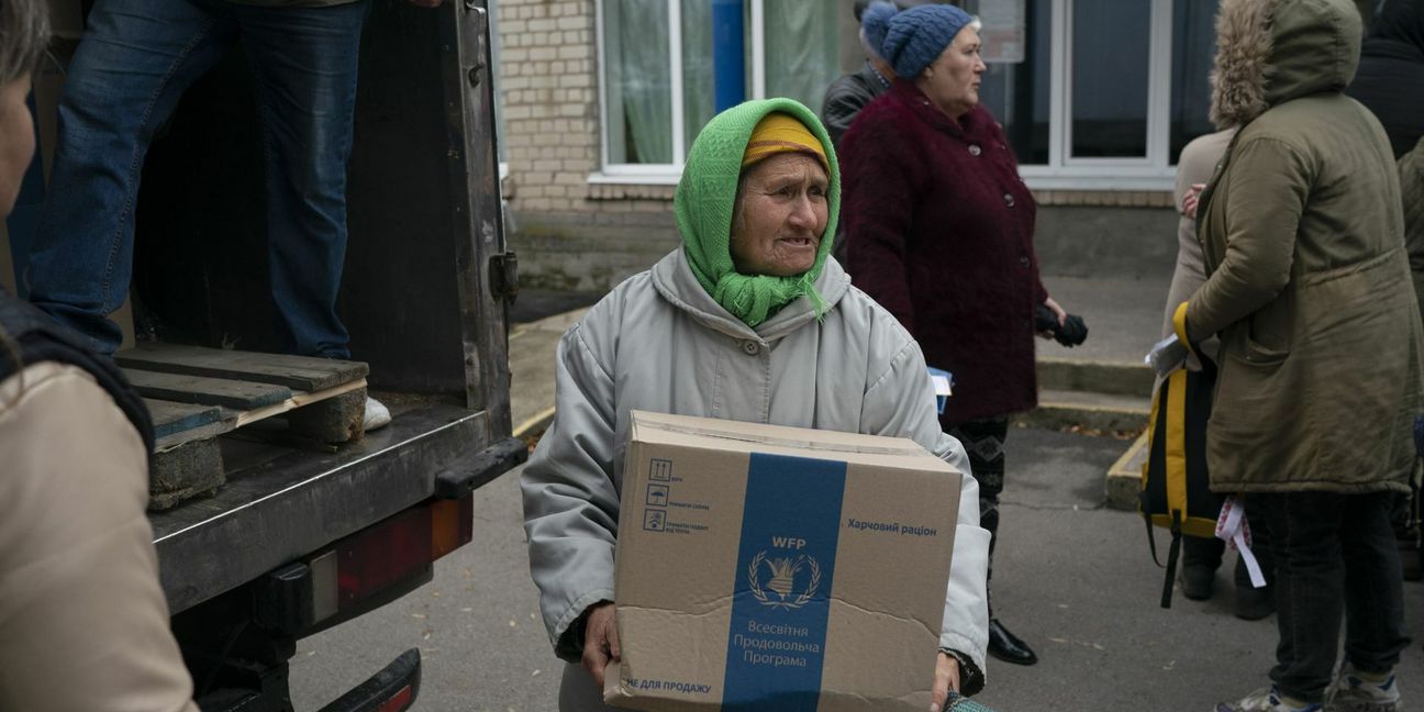 Eine Ukrainerin bekommt bei einer Hilfsaktion eine Kiste mit Spenden.