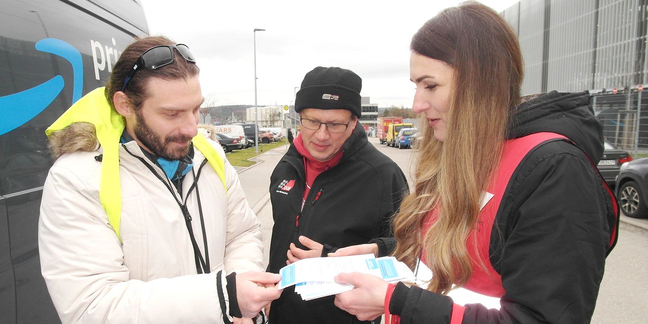 Die Regionalleiterin Dragana Bubulj des Beratungsnetzwerks „Faire Mobilität Südwest“ (rechts) und der baden-württembergische DGB-Vorsitzende Kai Burmeister (Mitte) im Gespräch mit einem Paketzusteller aus Albanien. Bild: Staber